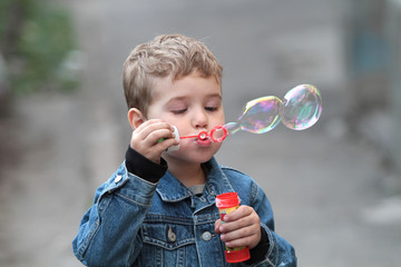 The boy in the denim jacket blows bubbles © zatvorniknik
