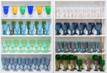 Colorful glasses and vases on the shelf in the souvenir shop. wine glasses stand on the shelves in a large supermarket