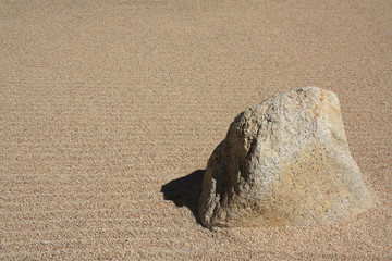 Sand with texture and design with a big rock