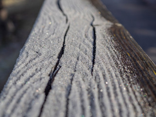 Detalle de hielo sobre un banco de madera en invierno.