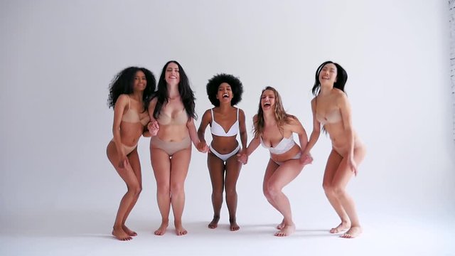 Group of multi ethnic women with different kind of beauty and body, posing and having fun in a studio