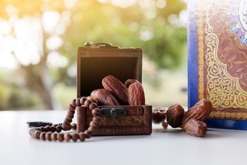 Ramadan kareem with dates, rosary and holy quran on fresh green background