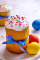 Easter cakes and colored eggs on a white table