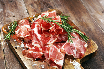 Italian sliced cured coppa with spices. Raw ham. Crudo or jamon with rosemary