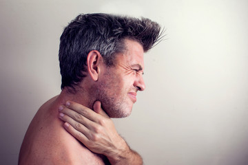 Obraz premium Man feels strong neck pain. People, healthcare and medicine concept