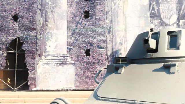 Weapons infantry fighting vehicle close-up on the background of the destroyed building, the city exhibition.