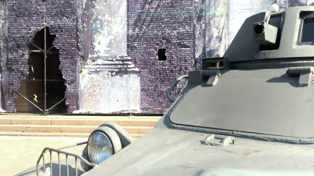 Infantry fighting vehicle stands on the background of the destroyed building, the city exposition.