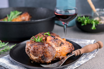 Roasted red meat and a glass of wine on the table. A hearty lunch with alcohol.