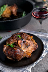 A large piece of fried meat on the bone in a plate and a glass of red wine. Hearty male lunch.