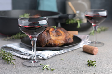 A large piece of fried meat on the bone in a plate and a glass of red wine. Hearty male lunch.