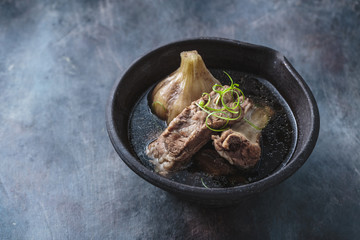 Close view of bak kut teh soup on dark background, copy space