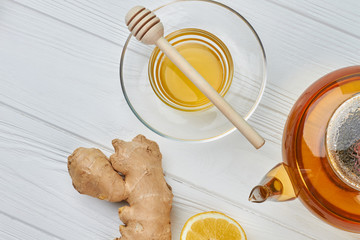 Ginger root, teapot and honey. Warming winter drink. Ginger tea recipe.