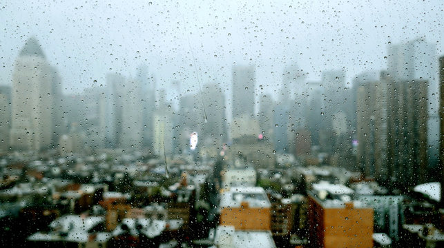 Rain Drops Pouring Down on Glass Window on a Cold Raining Day