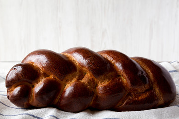 Homemade jewish challah bread on a white wooden background, side view. Closeup.