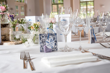 A room prepared for a wedding in a restaurant with tables beautifully laid in white