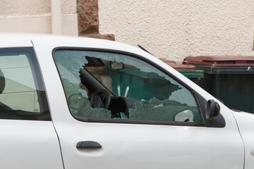 Broken window of a car parked in a street