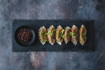 Japanese gyoza dumplings on black stone plate, copy space