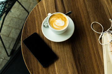 Smartphone, headphones, and a cup of coffee