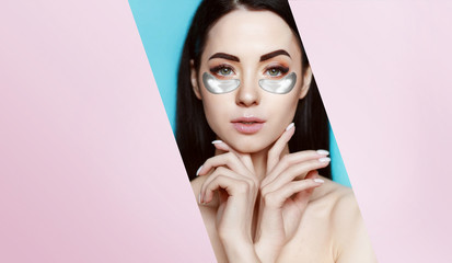 Beautiful young girl with eye patches. Lifting anti-wrinkle mask under eyes. Woman with perfect clean fresh skin. Silver cosmetics collagen hydrogel patches. Face care and beauty treatments.