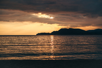 Obraz premium Beautiful view of the sunset or sunrise and the natural landscape with the sea and hills or mountains in Montenegro in the summer.