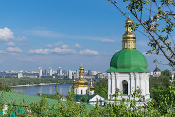 View of the city with church domes in the green trees. Churches in the summer surrounded by trees.