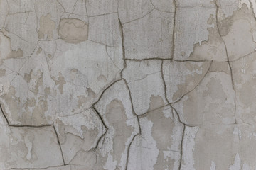 The texture of the old wall with cracked paint. Cracks in the concrete wall.