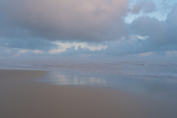 Morgan Bay beach at sunset, on the Wild Coast, Eastern Cape, South Africa. The clouds are reflected in the water on the sand. 