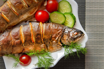 baked fish in a plate with vegetables