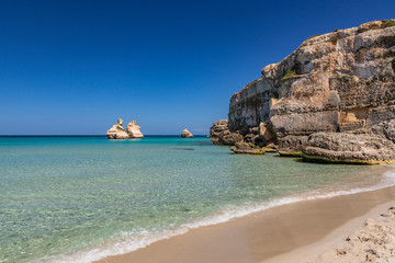 The bay of Torre dell'Orso, with its high cliffs, in Salento, Puglia, Italy. Turquoise sea and blue...