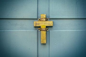 Golden christian old cross on wooden background. Symbol of religion, faith in God.