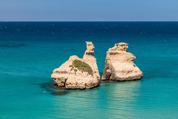 The bay of Torre dell'Orso, with its high cliffs, in Salento, Puglia, Italy. Turquoise sea and blue...