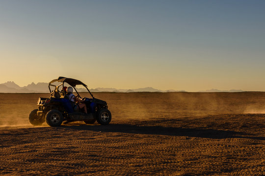 Unrecognizable people driving buggy during safari trip at sunset in Arabian desert not far from the Hurghada city, Egypt