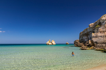 The bay of Torre dell'Orso, with its high cliffs, in Salento, Puglia, Italy. Turquoise sea and blue...