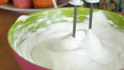 Kitchen mixer whips cream custard pastry whisk rotates rapidly. Food processor beat the eggs white egg whites into a thick foam. Kitchen machine in operation.
