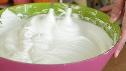 Kitchen mixer whips cream custard pastry whisk rotates rapidly. Food processor beat the eggs white egg whites into a thick foam. Kitchen machine in operation.