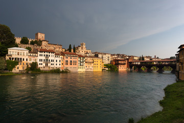 Fototapeta na wymiar Bassano del Grappa brenta river and wooden bridge before a storm