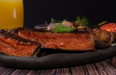 cooked steak with fried tomatoes, onions , dill and rosemary.selective focus, close-up