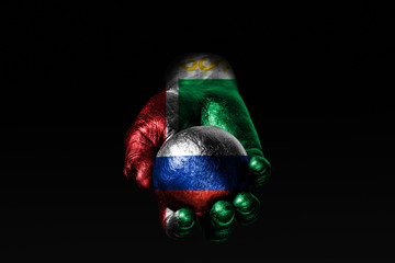 A hand with a drawn Chechnya flag holds a ball with a drawn Russia flag, a sign of influence,...