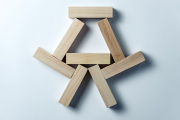 abstract geometric figure from wooden cubes, on an uneven white background. Horizontal frame