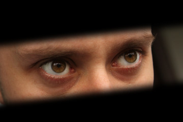 The look of a man looking out of the dark, the concept of shadowing, peeping, riddles; shot with...