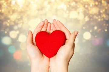 Obraz premium Hands of young woman holding red heart
