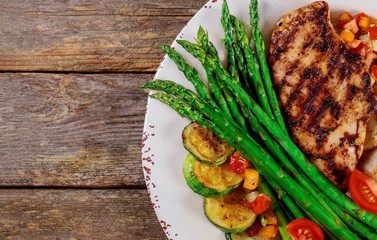 Grilled steaks, potato chips and asparagus ,zucchini on white plate