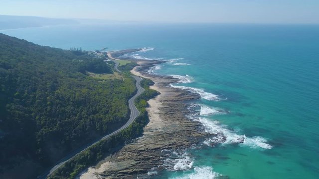 Aerial panoramic reveal of Great Ocean Road bends along rugged coastline