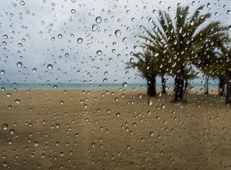 Vista de la playa a través del paraguas en un día de lluvia