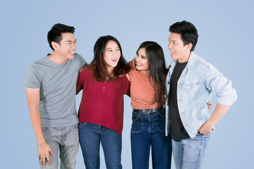 Fototapeta premium Young happy people embrace each other on studio