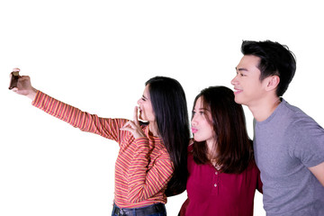 Young people taking selfie together on studio