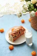 Bread, milk, fruit and flowers on the table