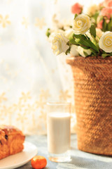 Bread, milk, fruit and flowers on the table