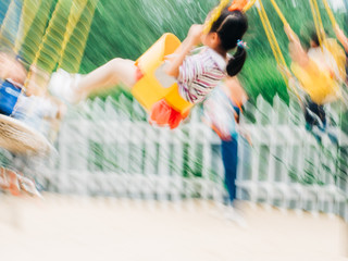 Children swinging on the playground blur motion