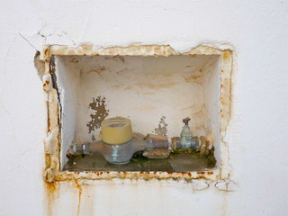 Damaged old masonry. Hole in an old wall. Part of an defective exposed water pipe with stopcock in...